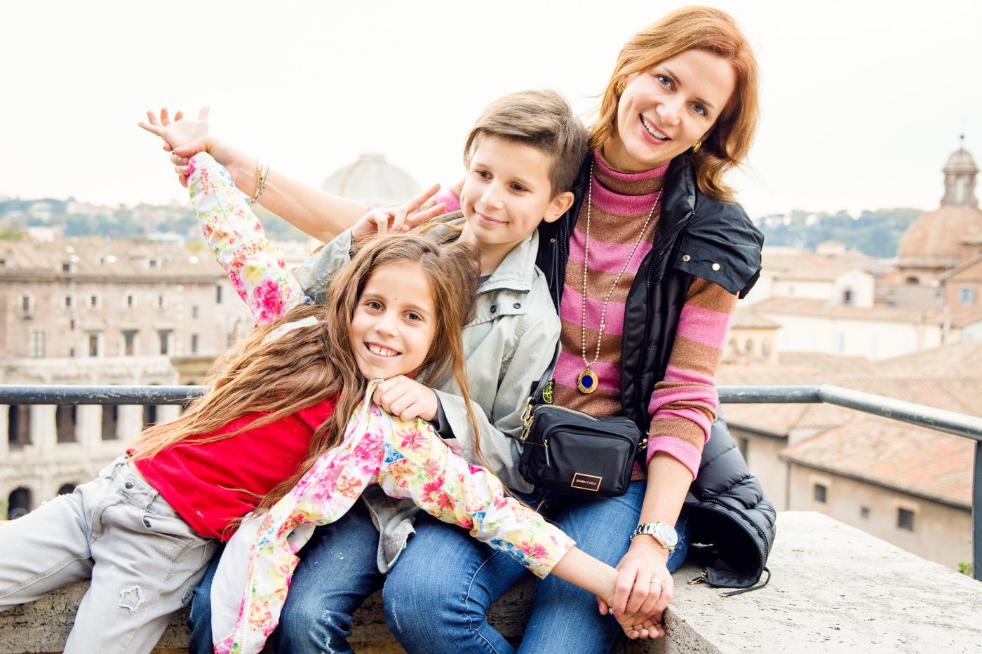 Una mamma con i bambini su una terrazza panoramica su Roma