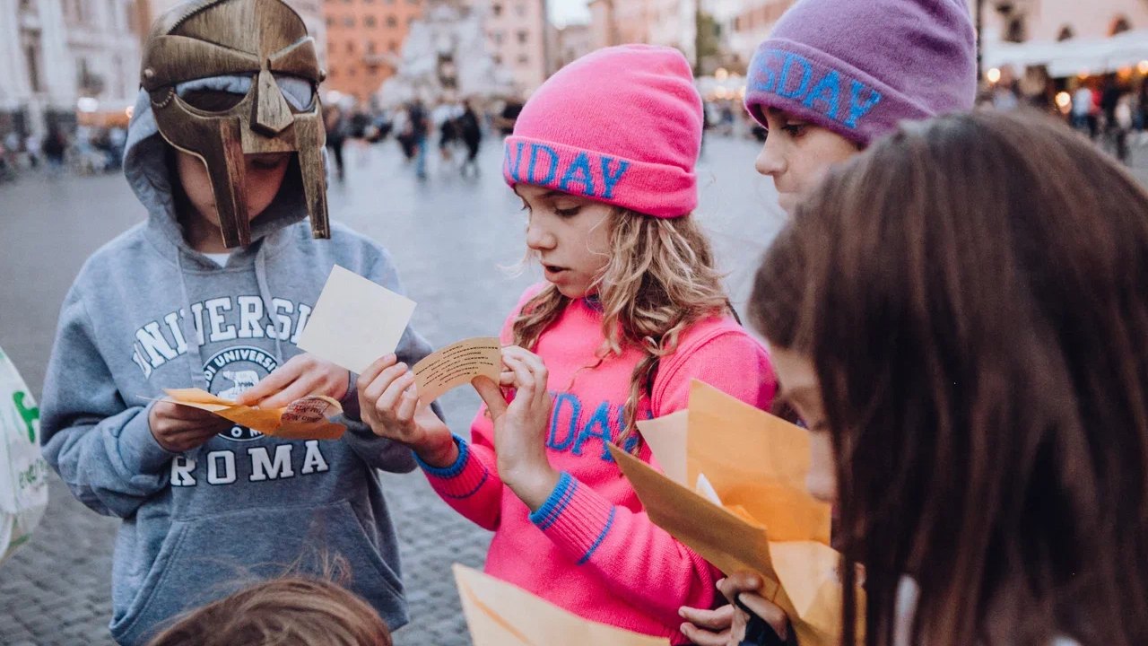 Bambini aprono le buste con le missioni del percorso