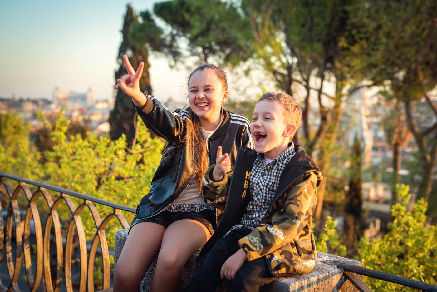 Due bambini esultano su una terrazza panoramica su Roma