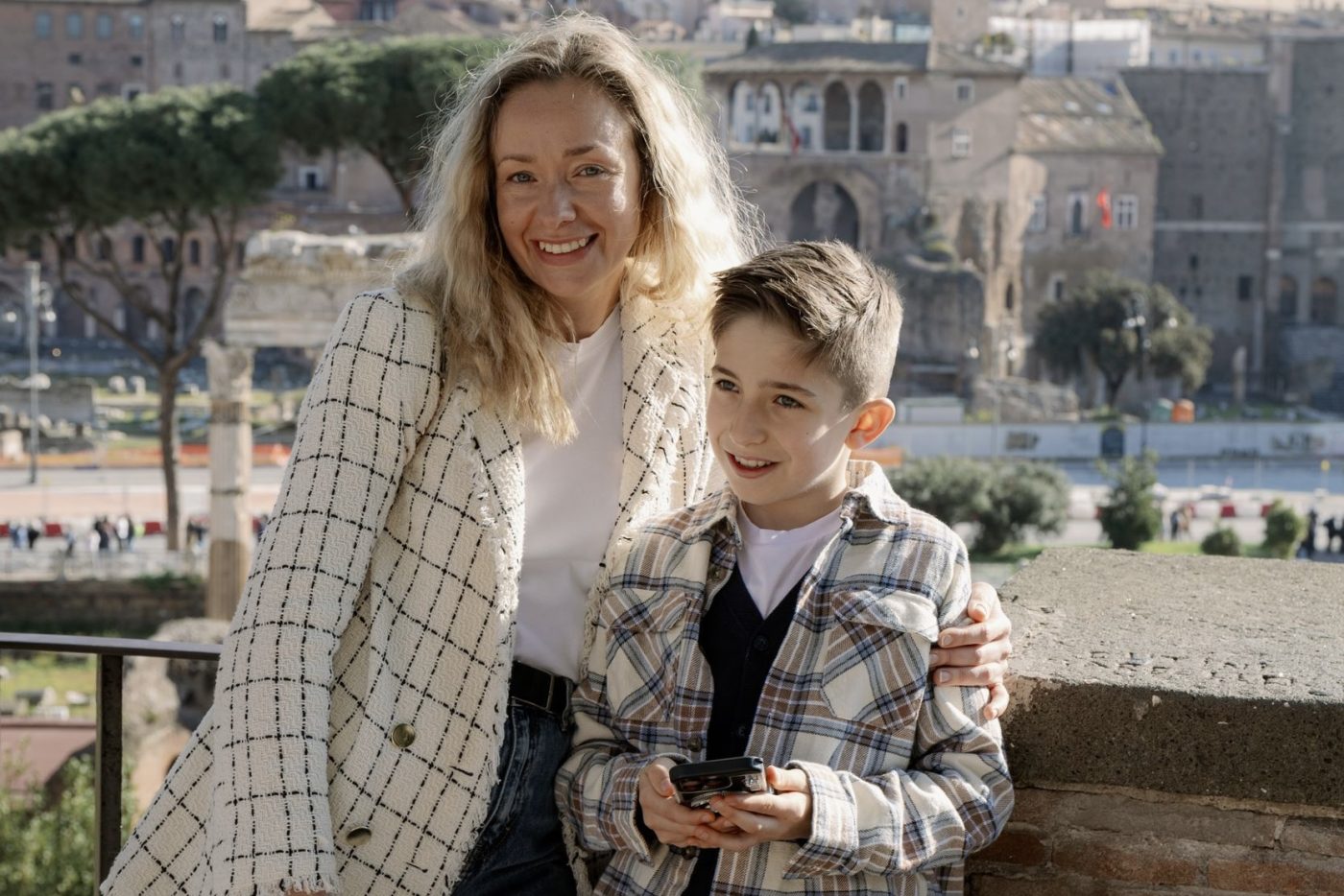 Il bambino mostra alla mamma una missione sul telefono sopra il Foro Romano
