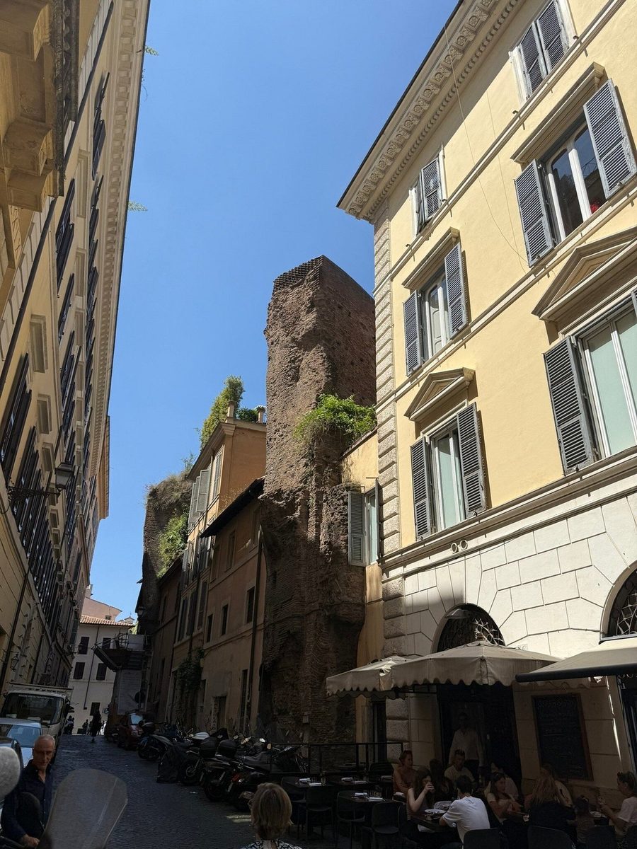 A narrow Roman street with old houses and ancient masonry