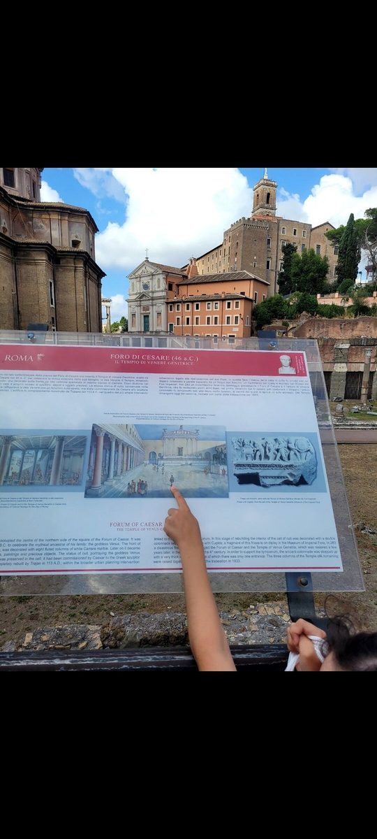 A child points at an information board above the Roman Forum
