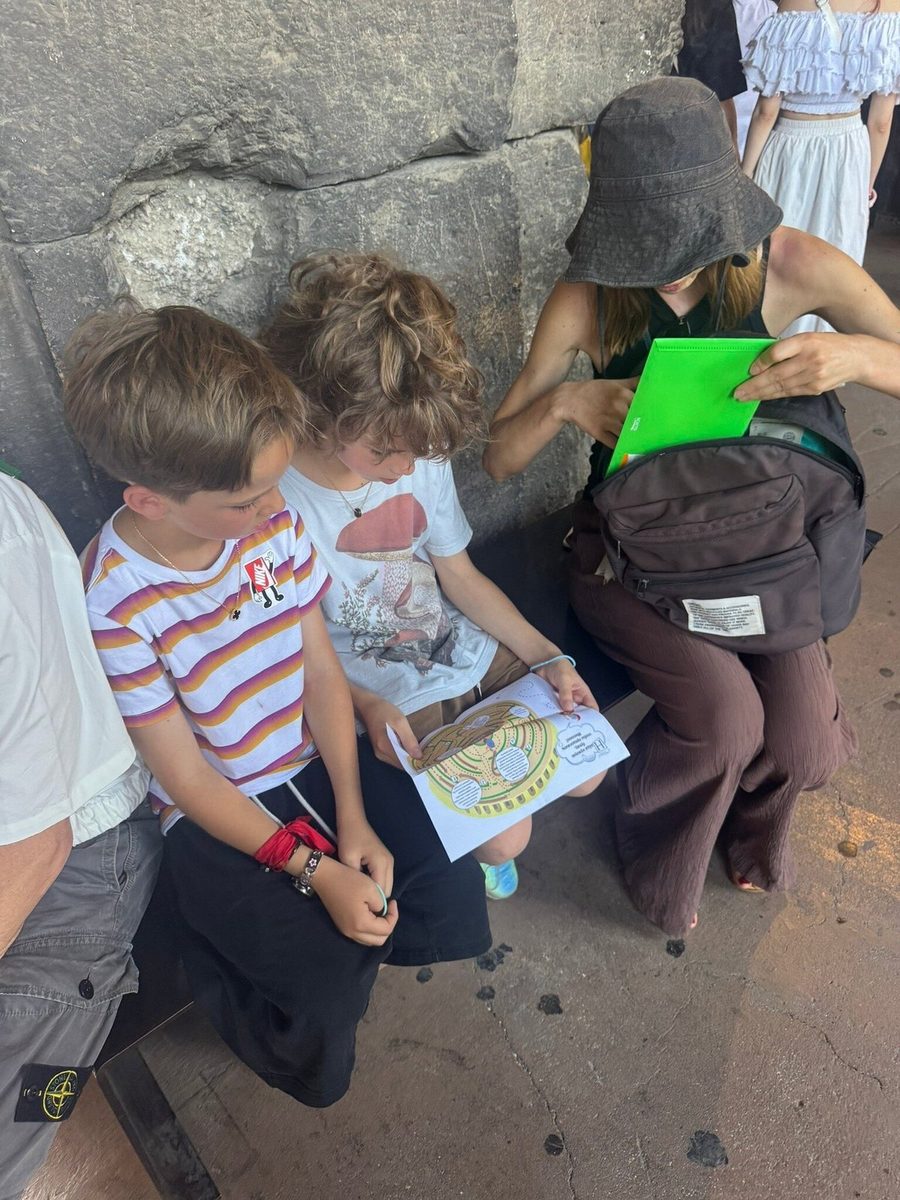 Children study the quest map by a stone wall