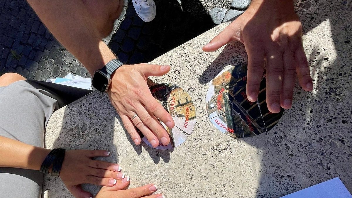 Participants’ hands over a quest task on a stone slab