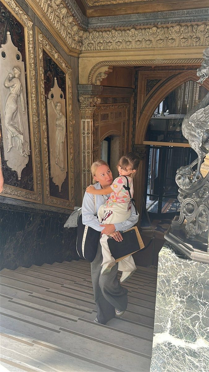 An adult with a toddler in a gilded hall of a Venetian palace