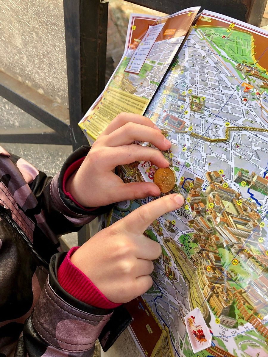 A child points to a spot on the map of Rome