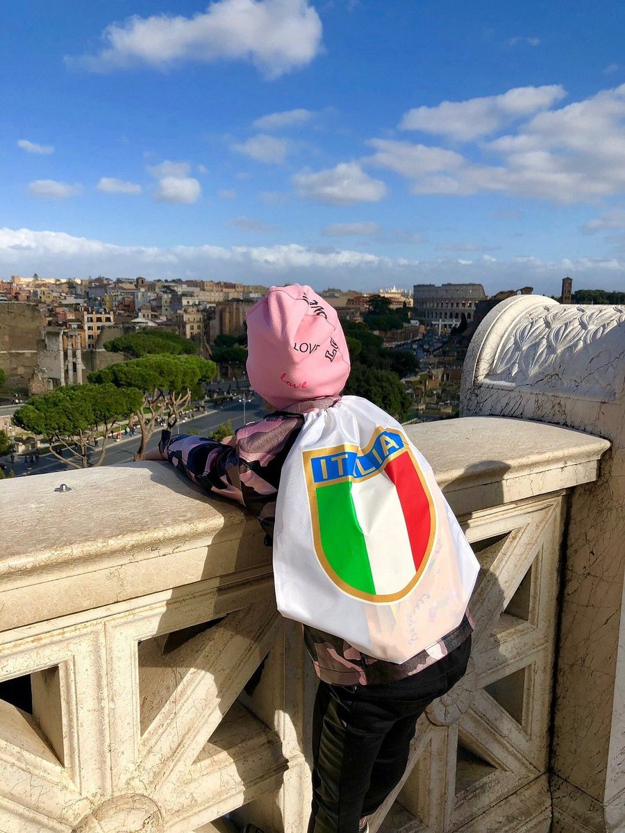 A child with a bag at a viewpoint over Rome