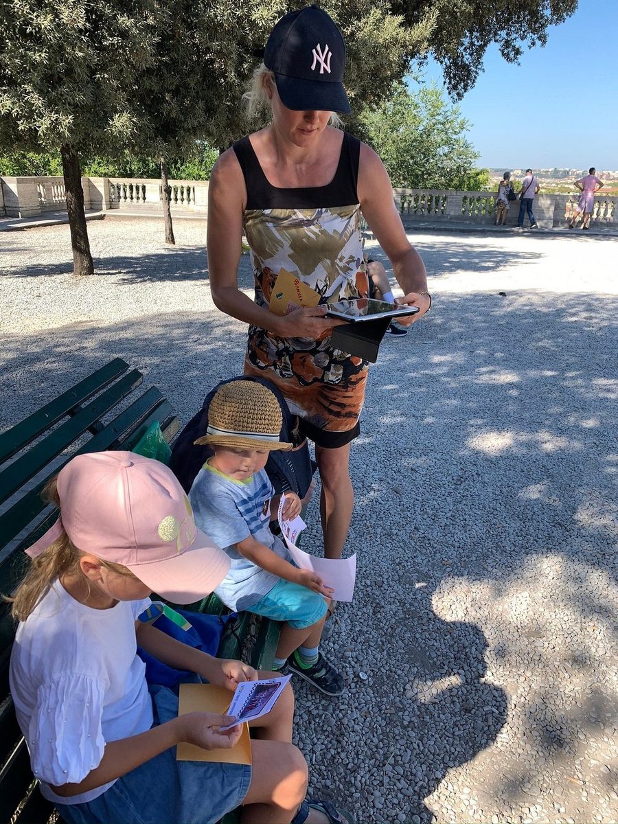 A woman and children go through the quest materials on a bench