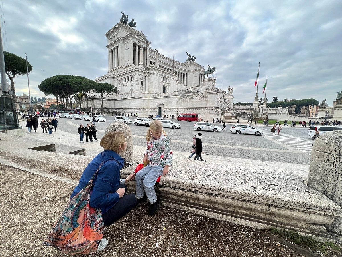 A woman with a child in Piazza Venezia by the Vittoriano