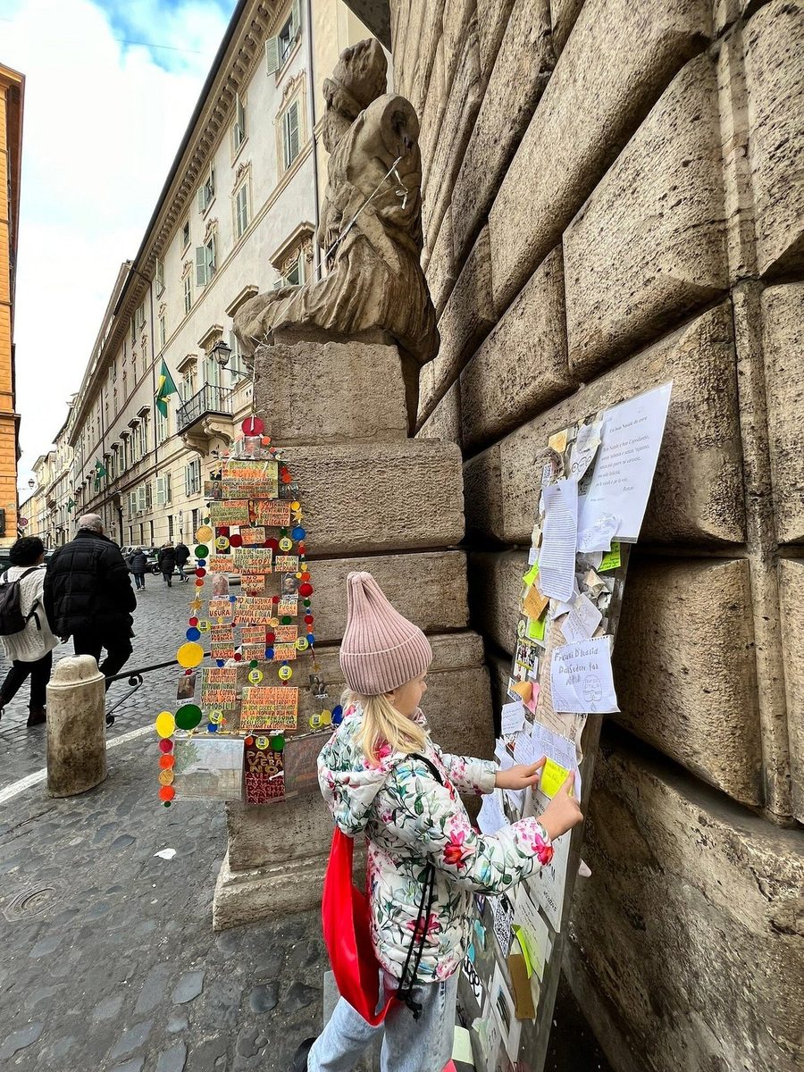 A child by a wall hung with souvenir trinkets