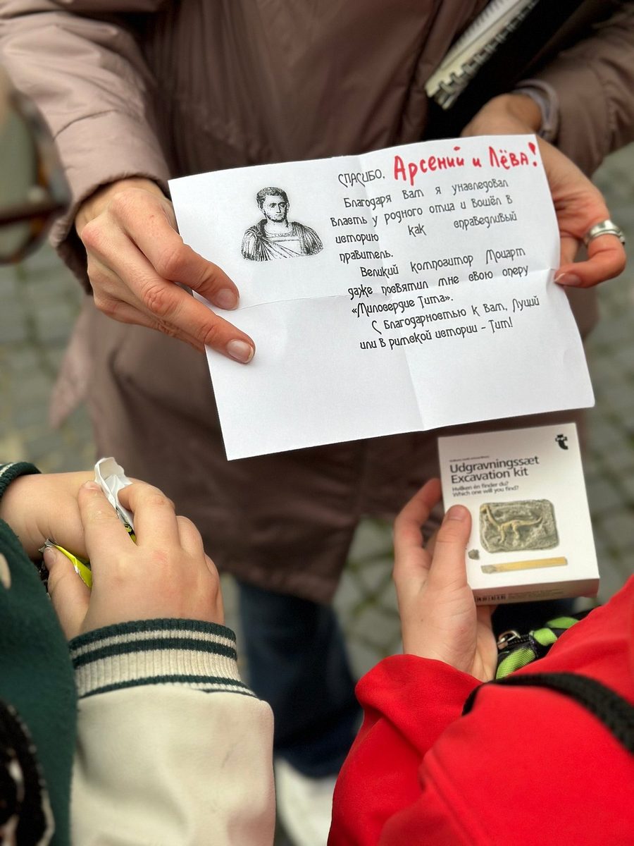 A child reads a quest card with the portrait of an emperor