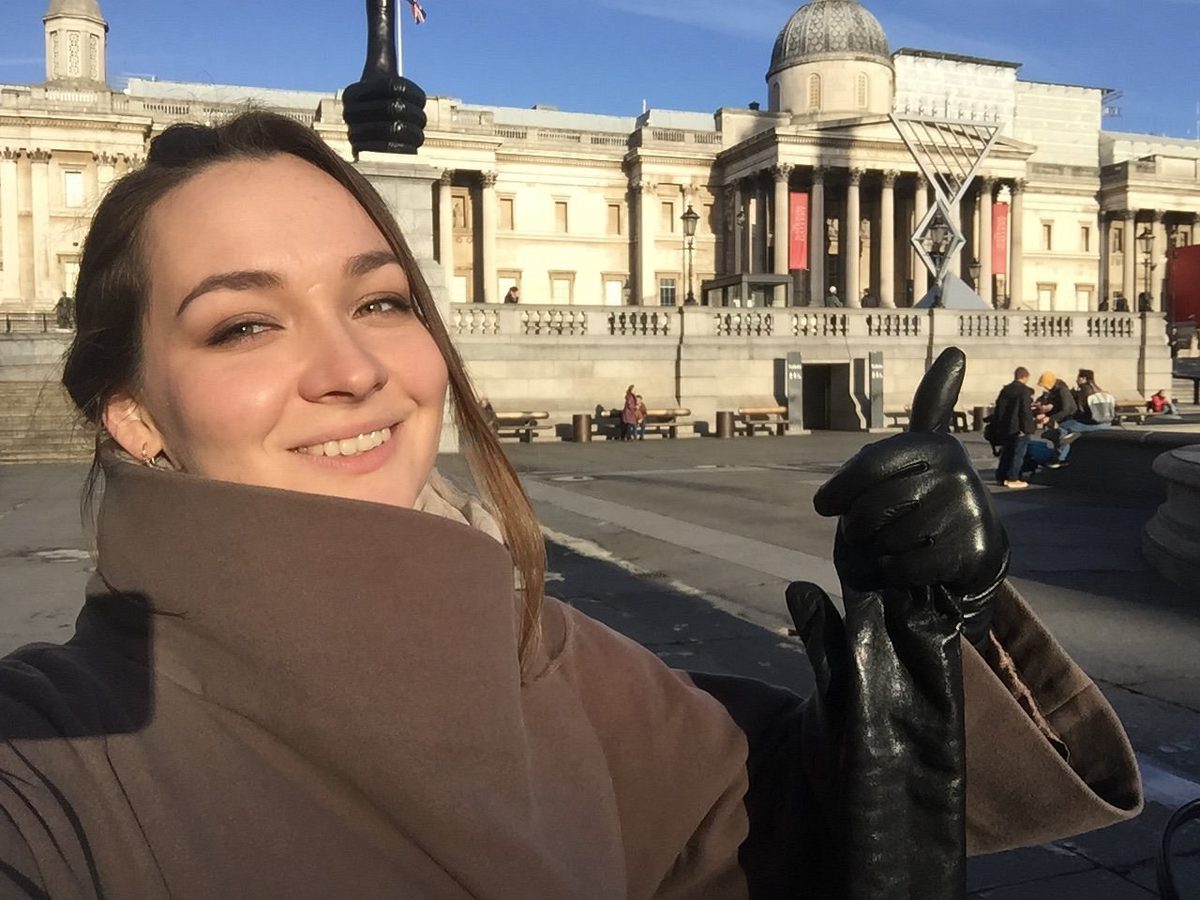 A guest takes a selfie in front of a classical facade