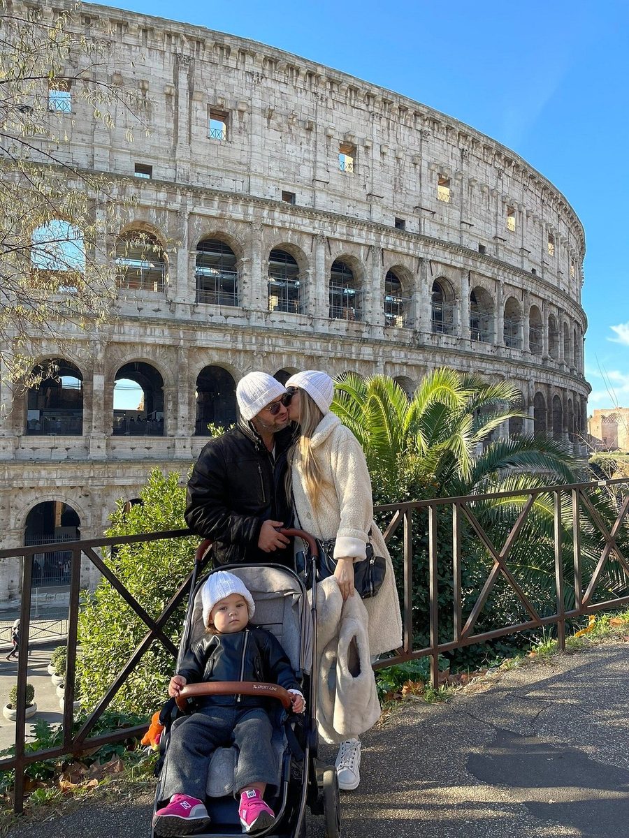 A mother with a pushchair by the walls of the Colosseum
