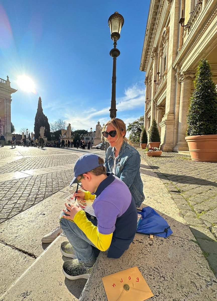 An adult and a child on a square against the light
