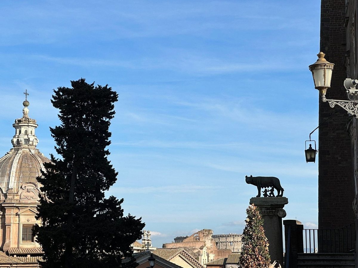 The silhouette of the Capitoline She-wolf and a dome at sunset