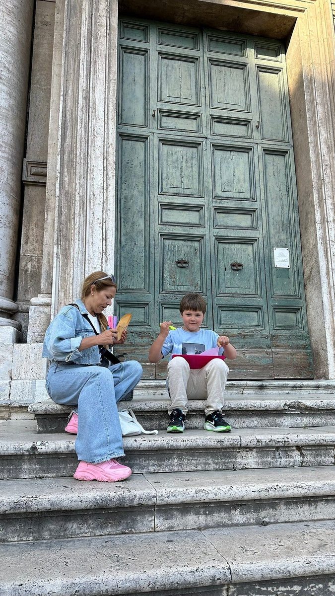 An adult and a child on the steps by an old door