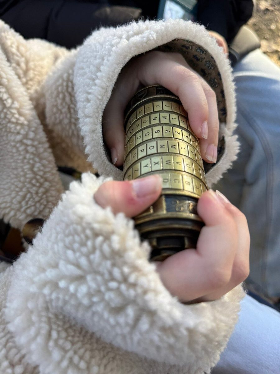 A child holds a bronze cryptex with a cipher, a quest prop