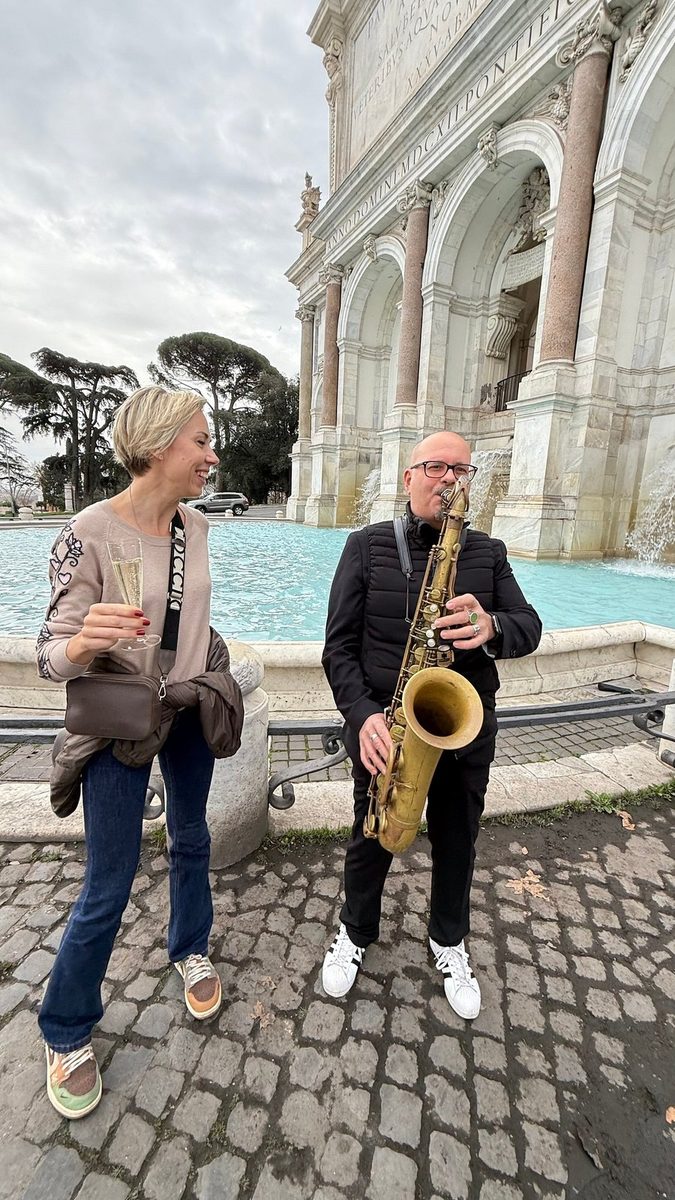 A saxophonist plays for a guest by the Vittoriano